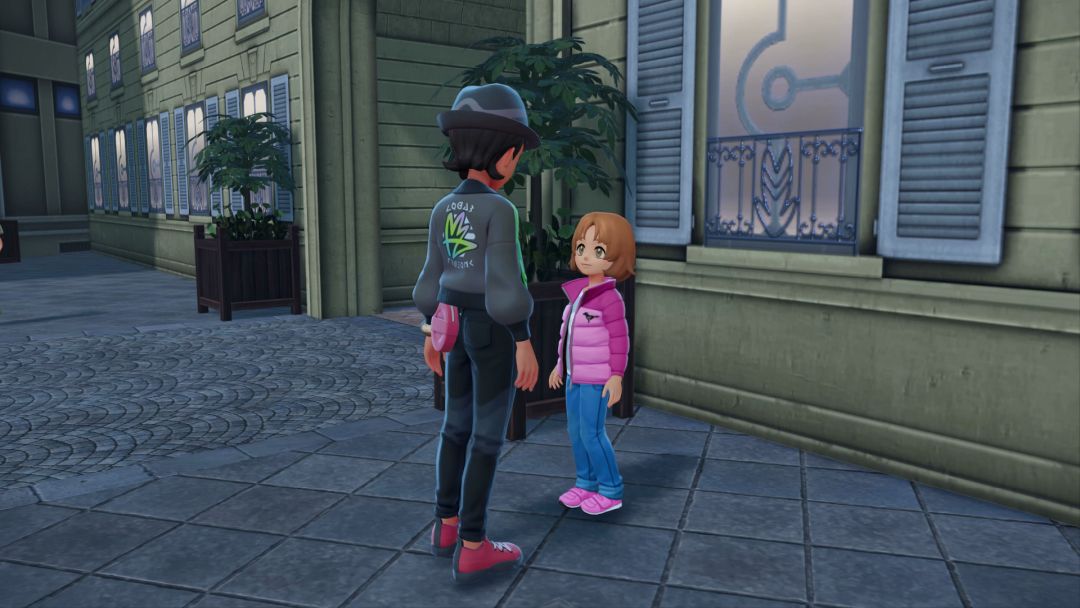 The Pokemon Trainer looks down at Ismene, a young girl standing along the sidewalk wearing jeans and a pink jacket.