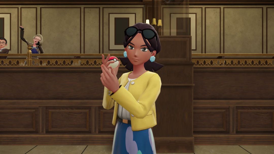 In the arena area within Restaurant Le Yeah, wearing a yellow sweater over a white blouse and skirt, Audrey the Gourmet holds up a Poke Ball.